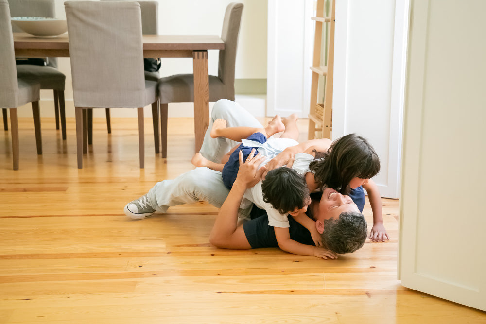 Family relaxing on new floor highlighting comfort and practicality of WPC vs PVC flooring for everyday home living.