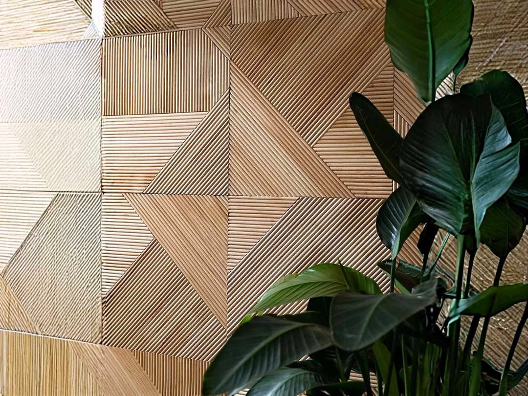 Stylish wooden wall paneling with a modern geometric pattern and green plant accent.