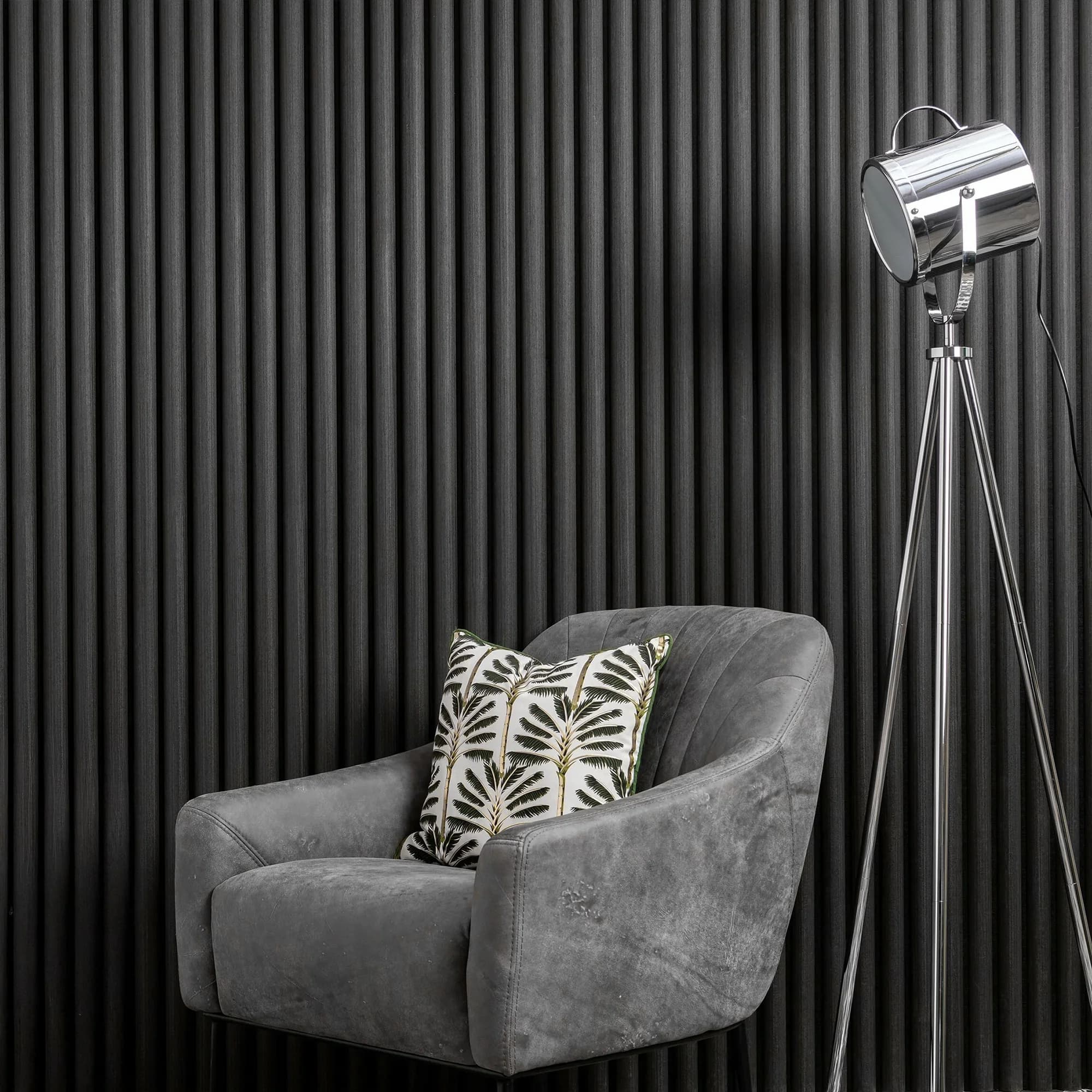 Grey armchair against a black slat wall