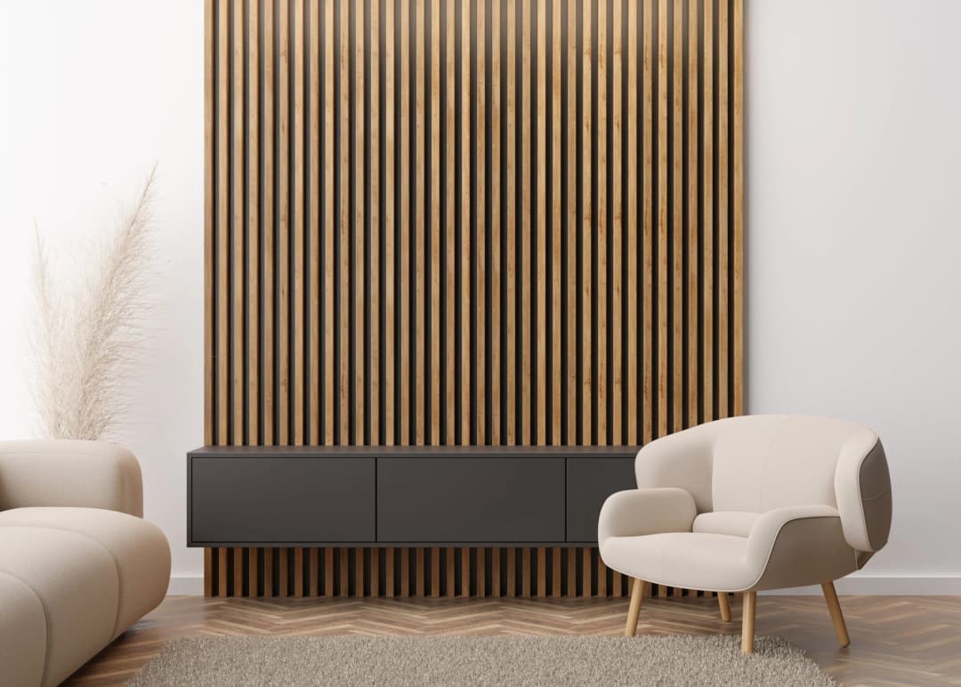 Modern living room interior featuring a dark wooden slat wall, beige armchair, floating black cabinet, and light neutral decor.