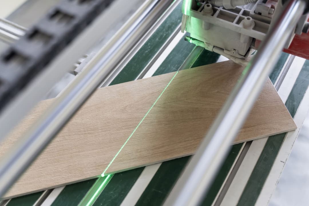 Laser cutting machine working on a real wood panel in a workshop.