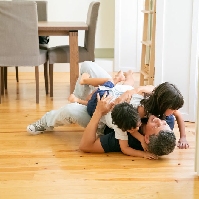 Family relaxing on new floor highlighting comfort and practicality of WPC vs PVC flooring for everyday home living.