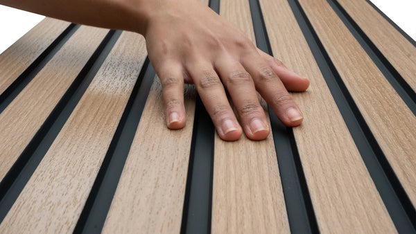 A hand touching a wood wall panel